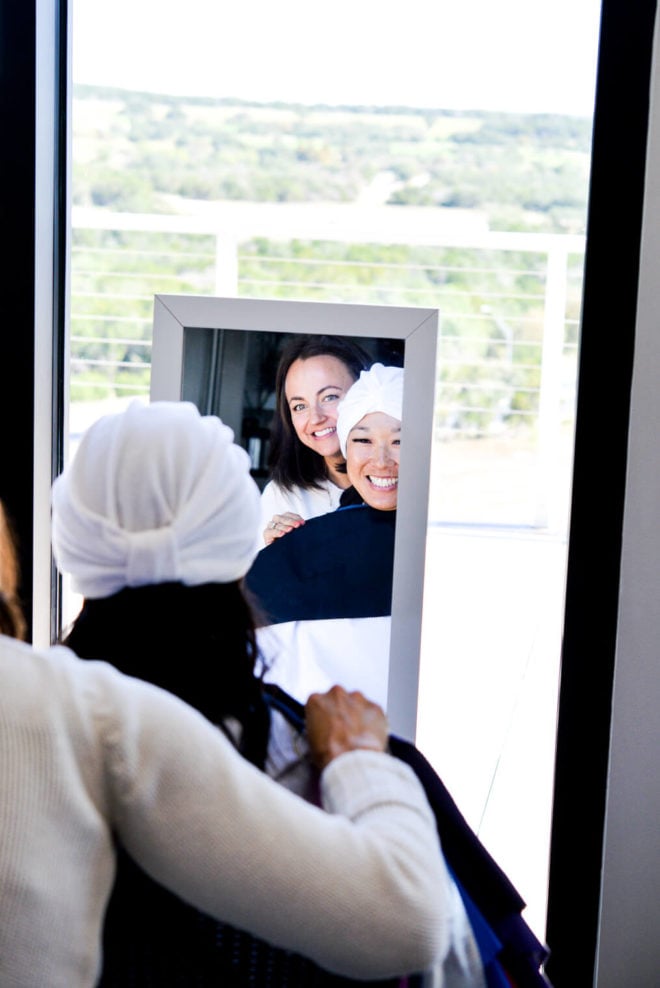 Mirror reflection of Melissa and Jordan smiling into the mirror.