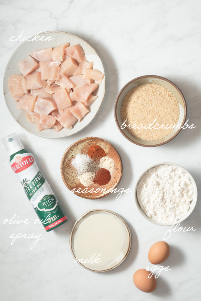 all of the ingredients for oven baked chicken nuggets on a marble surface