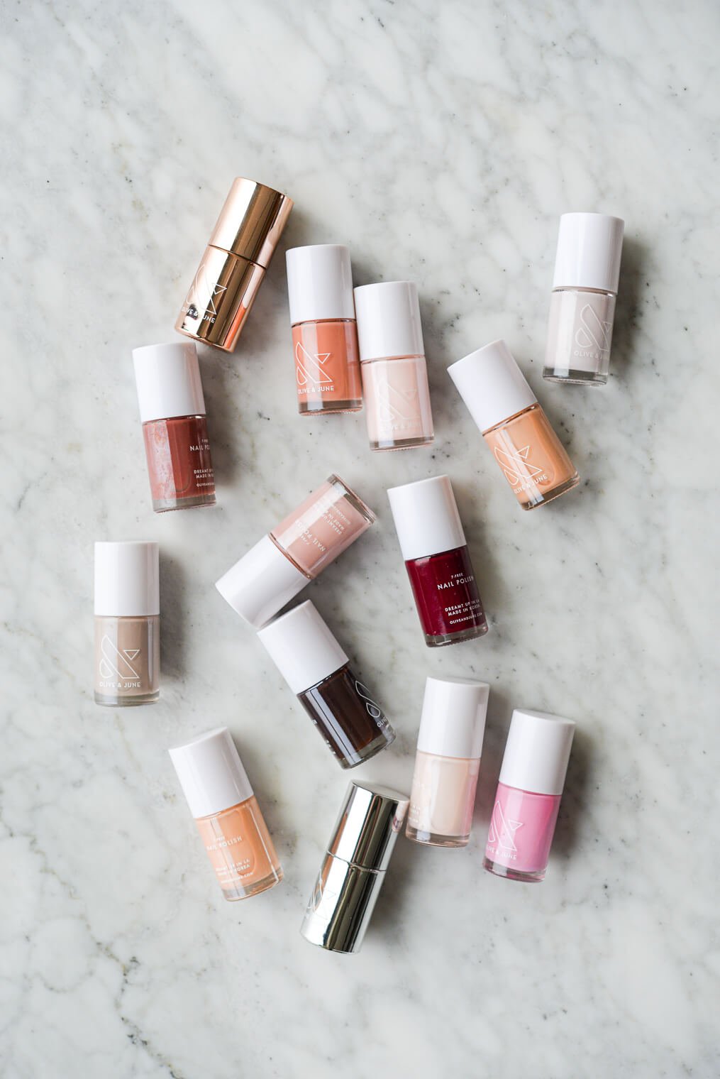 Assorted nail polish bottles on a marble surface.