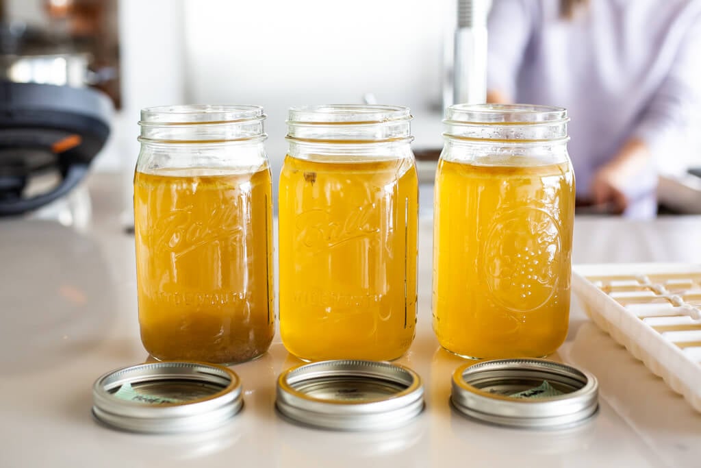 Three mason jars with lids in front of them side-by-side on a countertop.