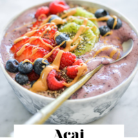 Acai smoothie bowl topped with variety of fruit and the words Acai Smoothie Bowl in black letters on the bottom.