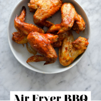 White plate with BBQ Chicken Wings on a marble surface with the words "Air Fryer BBQ Chicken Wings" in black letters on the bottom.