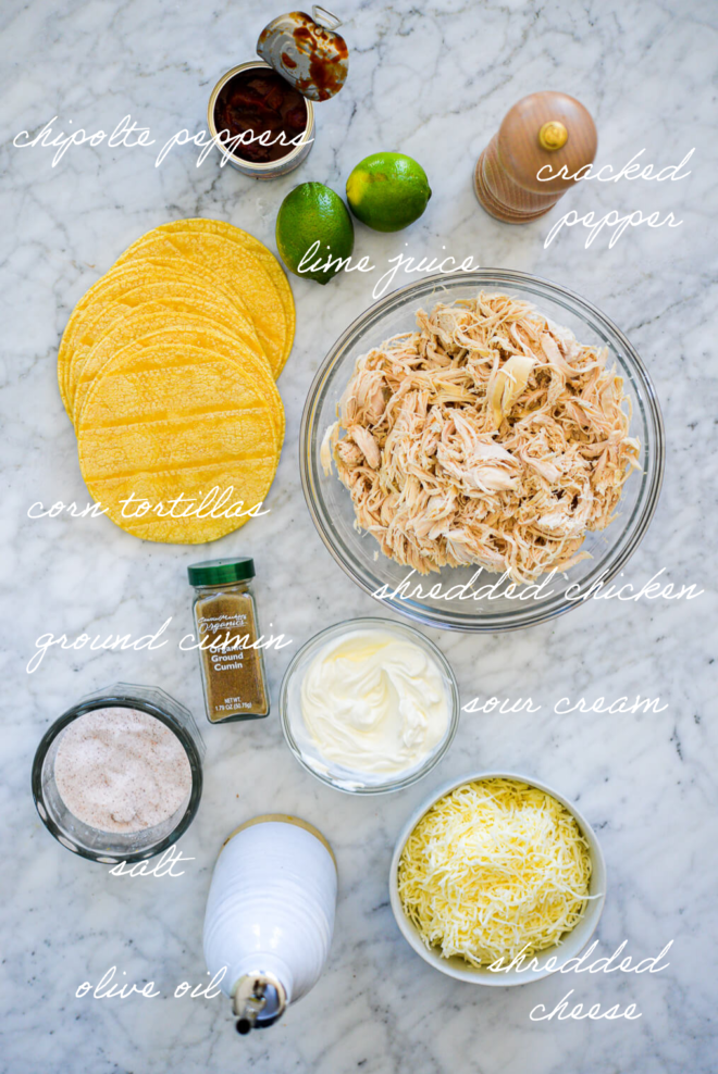 Chicken taco ingredients on a marble surface with ingredient labels written in white letters.