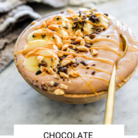 Chocolate smoothie bowl topped with sliced banana, cocoa nibs, peanuts, and a drizzle of peanut butter with "Chocolate Smoothie Bowl" written in black underneath and "Fed + Fit" in golden orange.