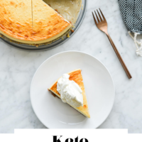 Top down view of slice of cheesecake on a white plate and whole cheesecake with a slice cut out on a marble surface with "Keto Cheesecake" written in black underneath and "Fed + Fit" in golden orange.
