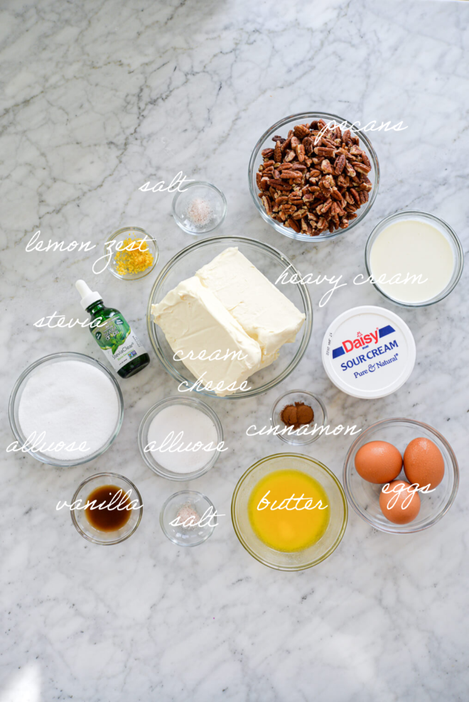 Top down shot of keto cheesecake ingredients with ingredient labels written out in white, cursive letters.