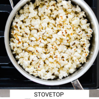 Pot on a stovetop with popcorn inside with the words "Stovetop Popcorn" written in black underneath and "Fed + Fit" in golden orange.