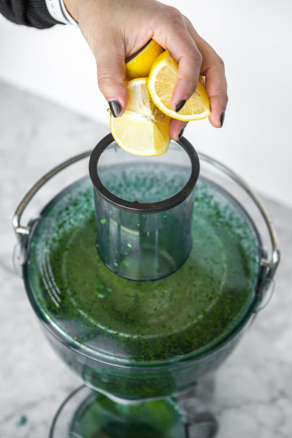 Lemon wedges being put into juicer.