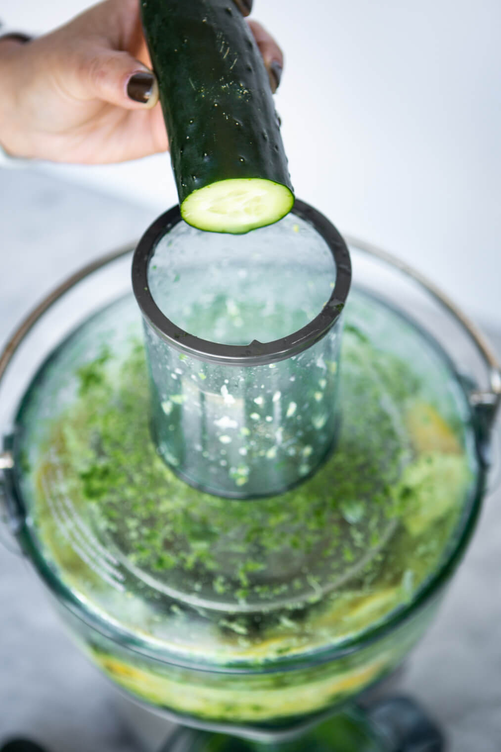 Cucumber being put into juicer.