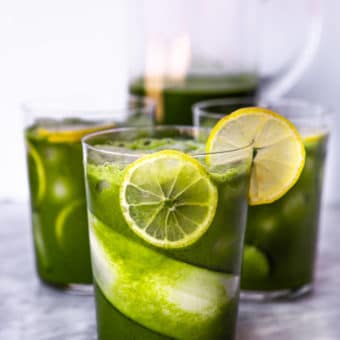 Three glasses lined with cucumber and lemon slices with ice and juice.