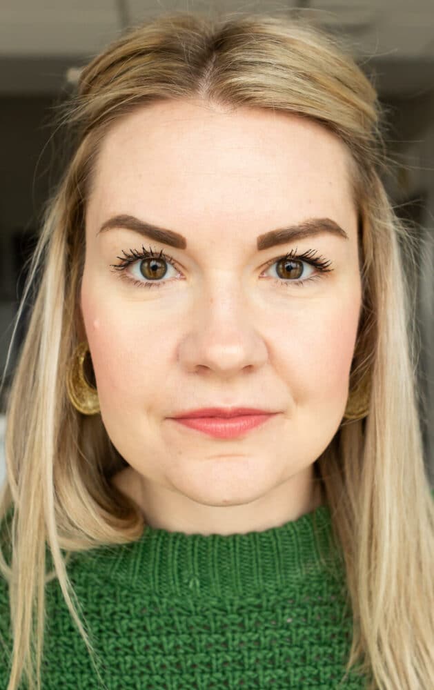 Headshot of Lauren wearing a Kelly green sweater not smiling.