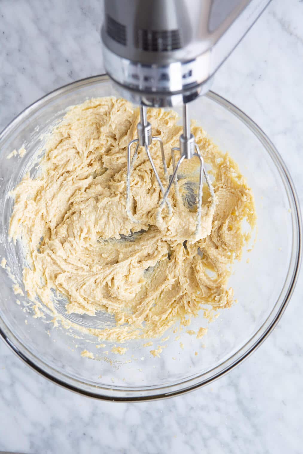 Butter and sugar creamed in a mixing bowl with a hand mixer.