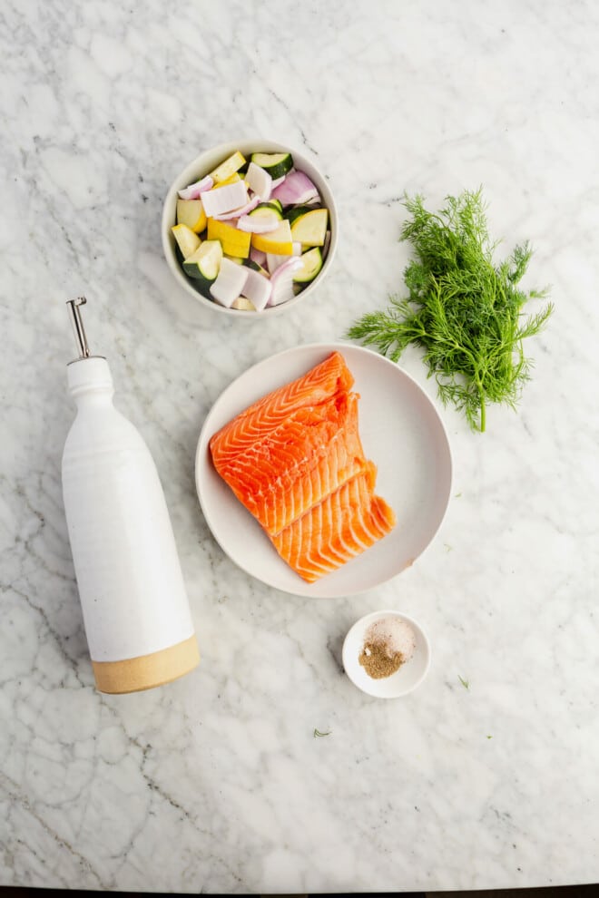 Air fryer salmon ingredients on a grey and white marble surface.