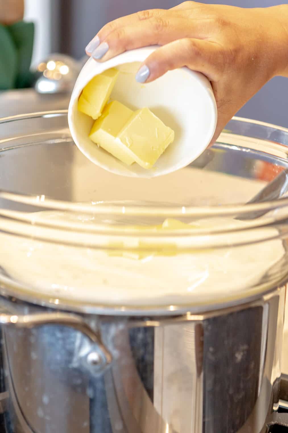 Buttermilk and butter being melted in a large, glass bowl over a double boiler.