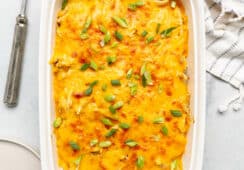 Top down photo of buffalo ranch chicken casserole in a white casserole dish on a gray and white marble surface.