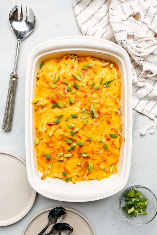 Top down photo of buffalo ranch chicken casserole in a white casserole dish on a gray and white marble surface.