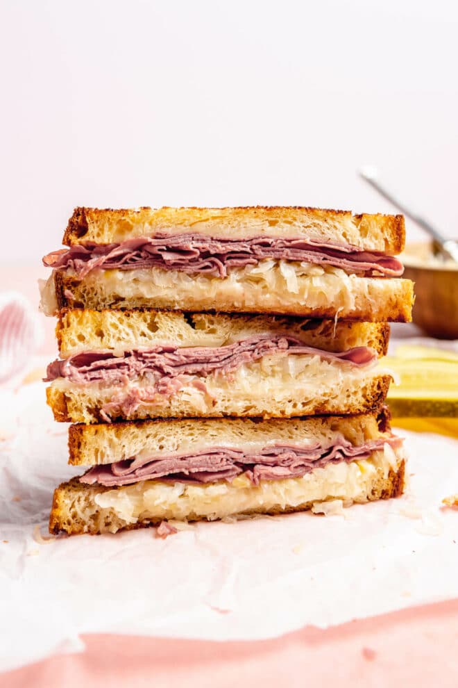 Stack of grilled cheese sandwiches with corned beef and cheese. 