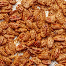 Candied pecans on white parchment paper.