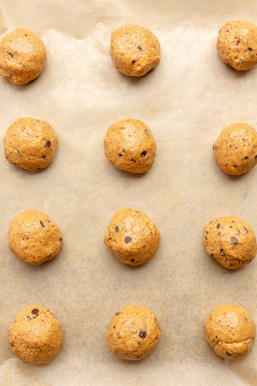 Peanut butter energy balls on a parchment lined baking sheet.