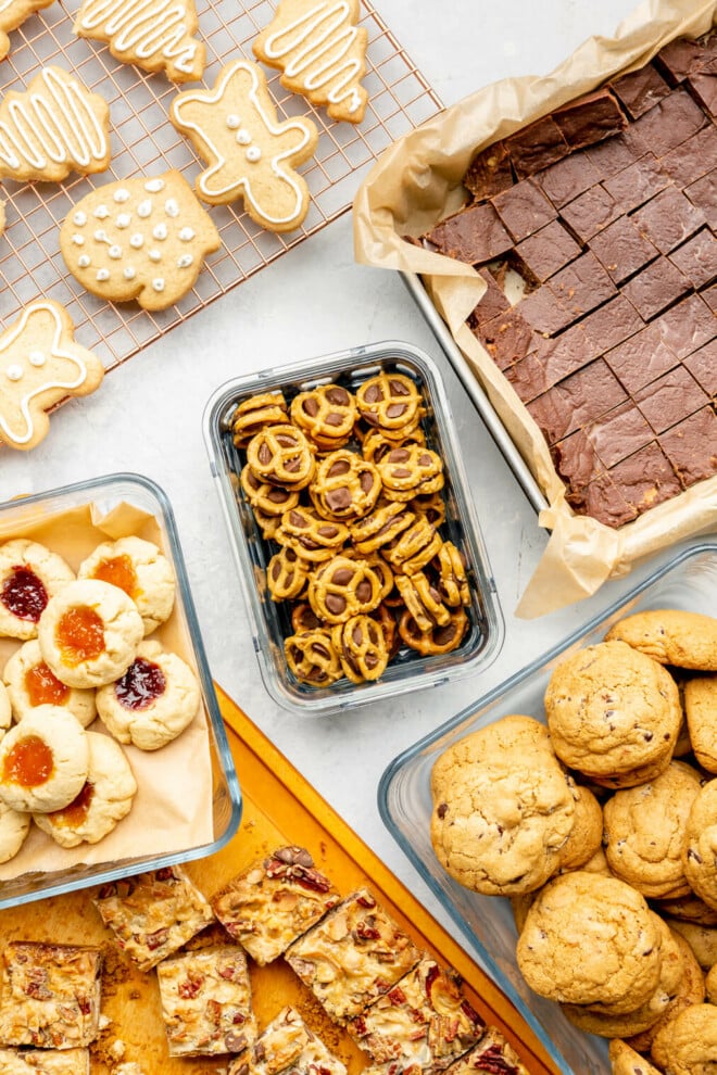 Variety of baked goods in various containers on a grey surface.