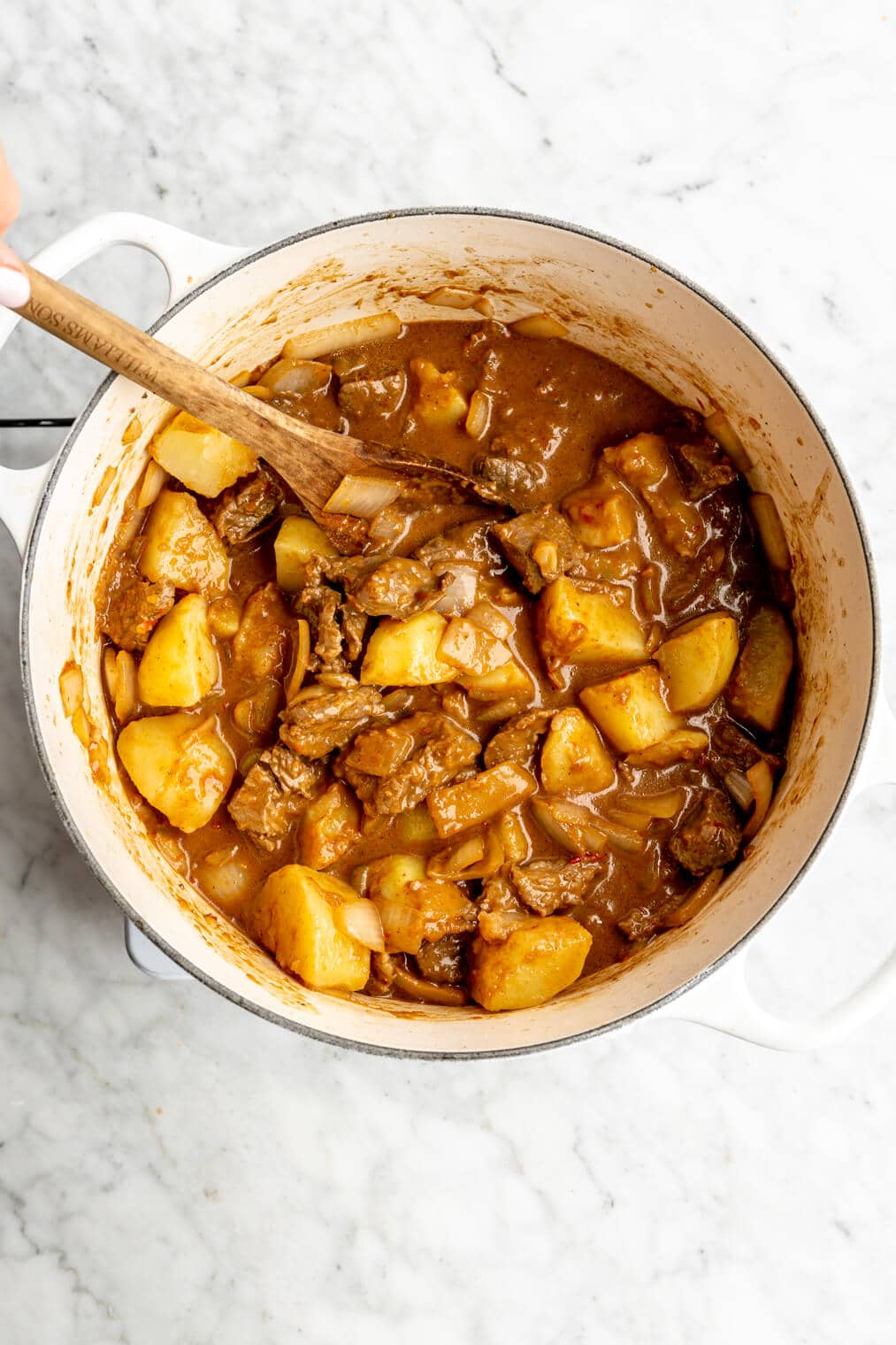 Beef massaman curry combined together in a white pot.