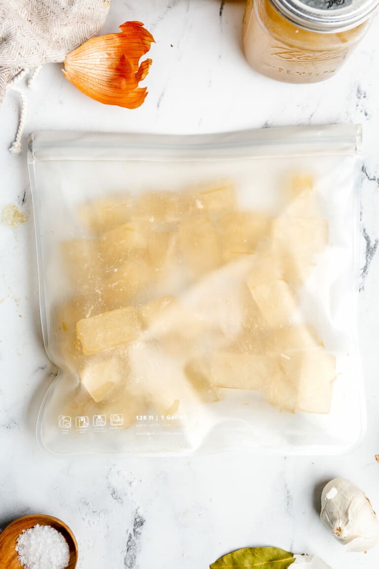 Frozen cubes of homemade chicken broth in a reusable bag.