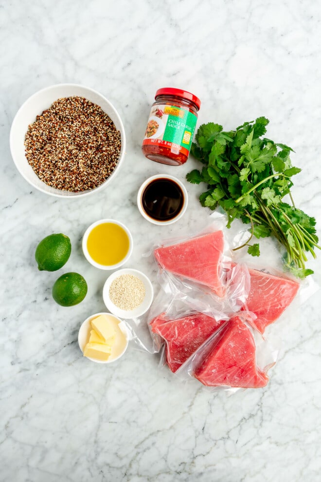 All of the ingredients needed for chili-lime seared ahi tuna steaks sitting on a marble surface.
