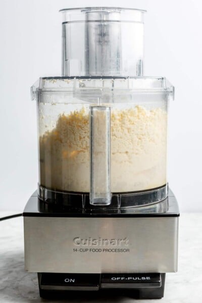 A food processor blending feta and honey.