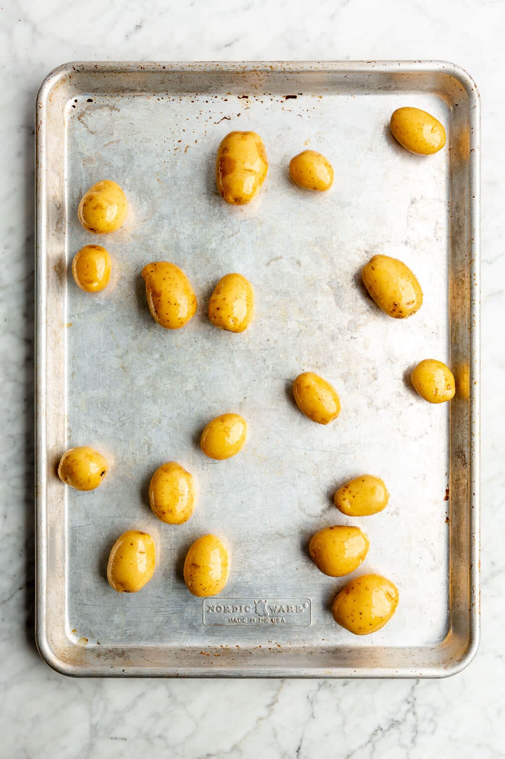 Baby potatoes spread out on a sheet pan.