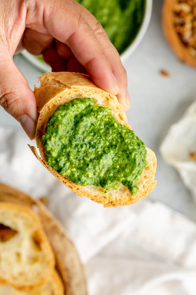 Pesto sauce on a toasted slice of crusty white bread.