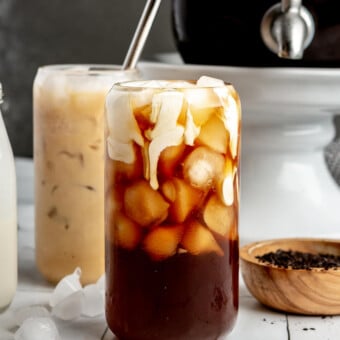 A glass of iced cold brew just after heavy cream has been poured into it.
