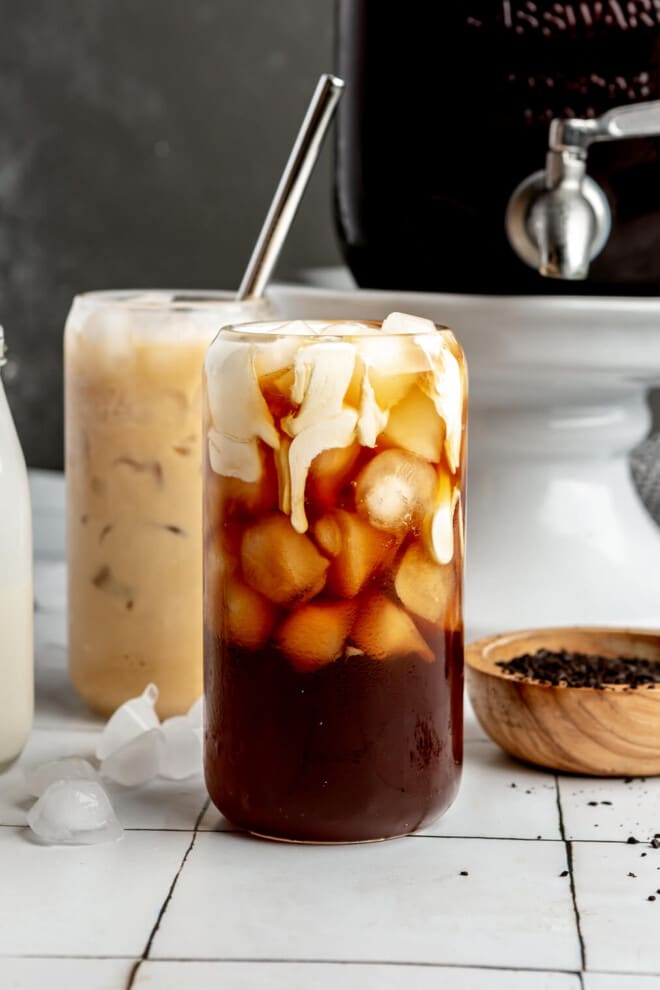 A glass of iced cold brew just after heavy cream has been poured into it.