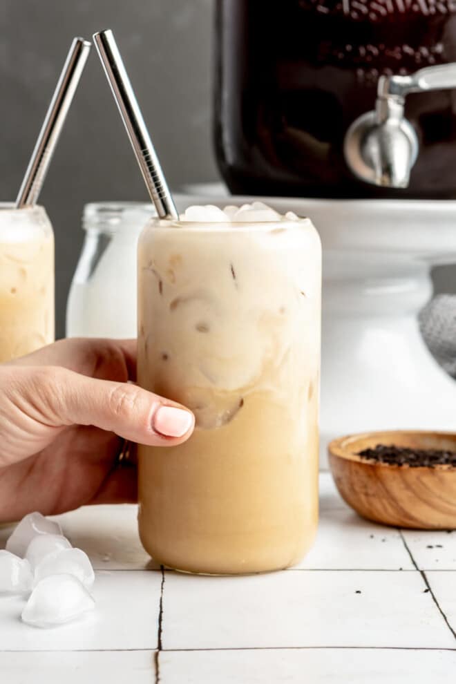 A person holding a glass of cold brew coffee.