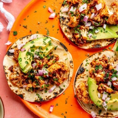 A plate of three cauliflower tinga tacos.