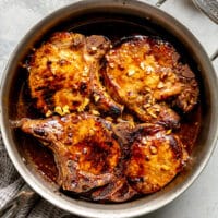 A skillet of 4 cooked honey garlic pork chops