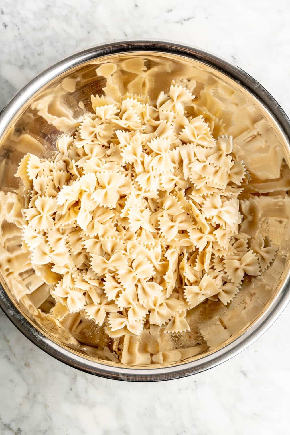 Bowtie pasta in a large metal bowl.