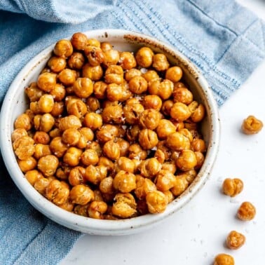 A small bowl of crispy air fryer chickpeas on a marble surface.