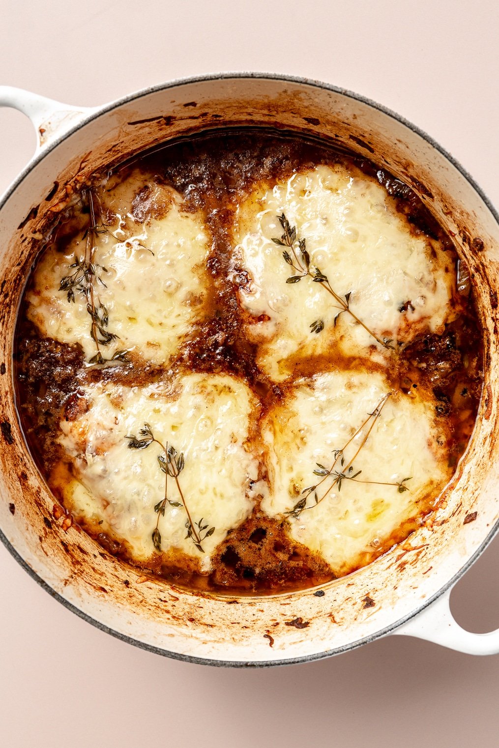 An enameled cast iron pot with a french onion chicken bake (chicken breasts, caramelized onions, and melted gruyere cheese)