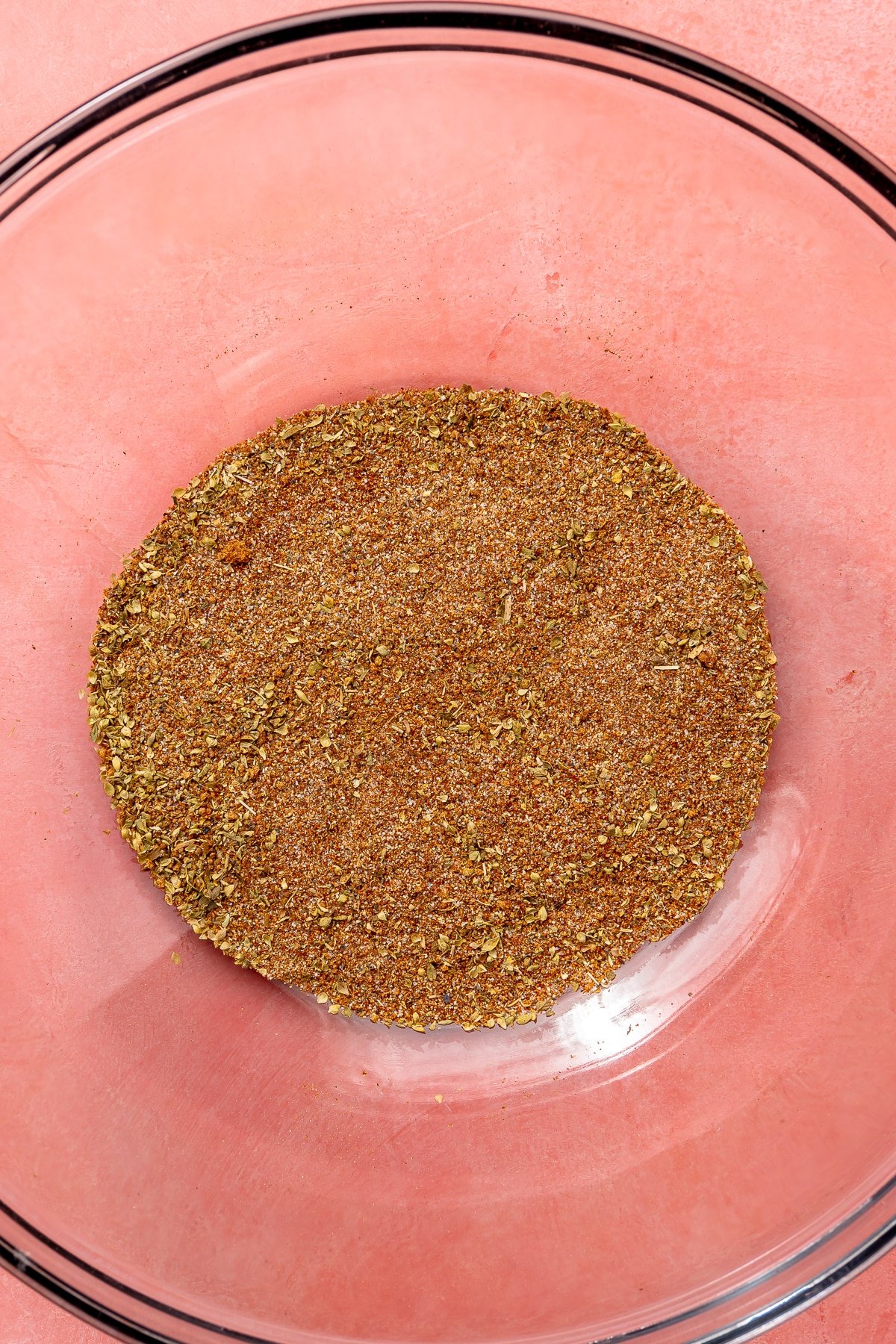 A variety of mixed spices have been added to a glass bowl.