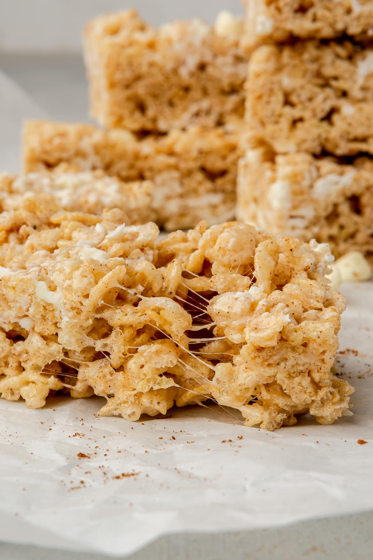 A Pumpkin Spice Rice Krispie Treat that has been slightly pulled apart to show gooey strings of marshmallow.