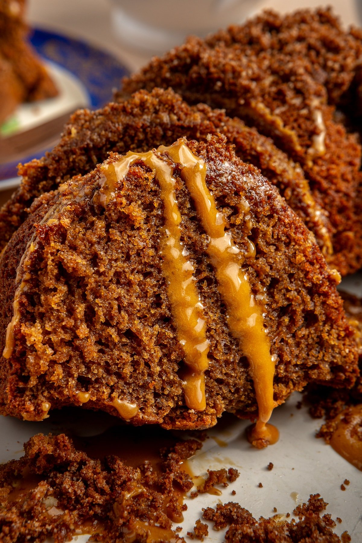 A slice of pumpkin spice bundt cake with cold brew icing sliding down the side of it.