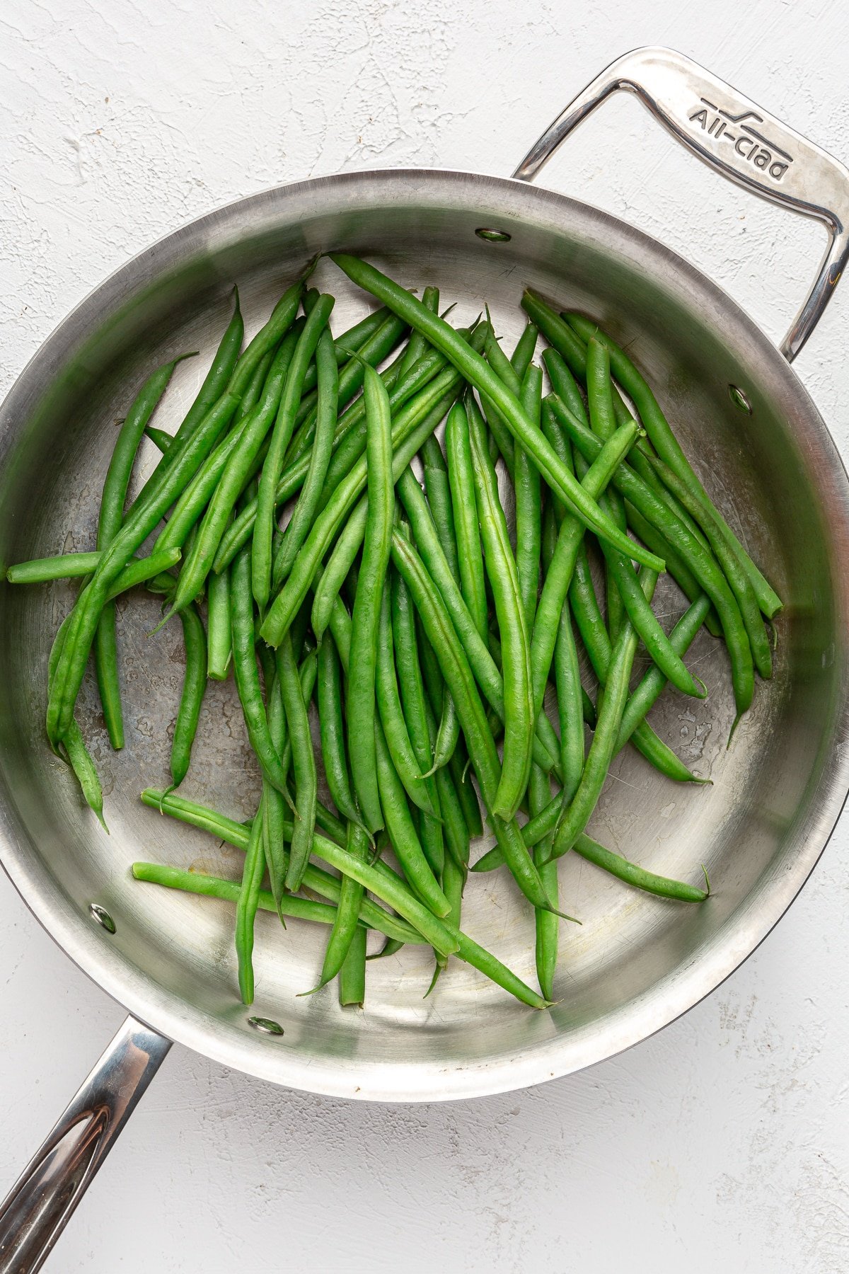 Green beans have been placed in the pan with water.