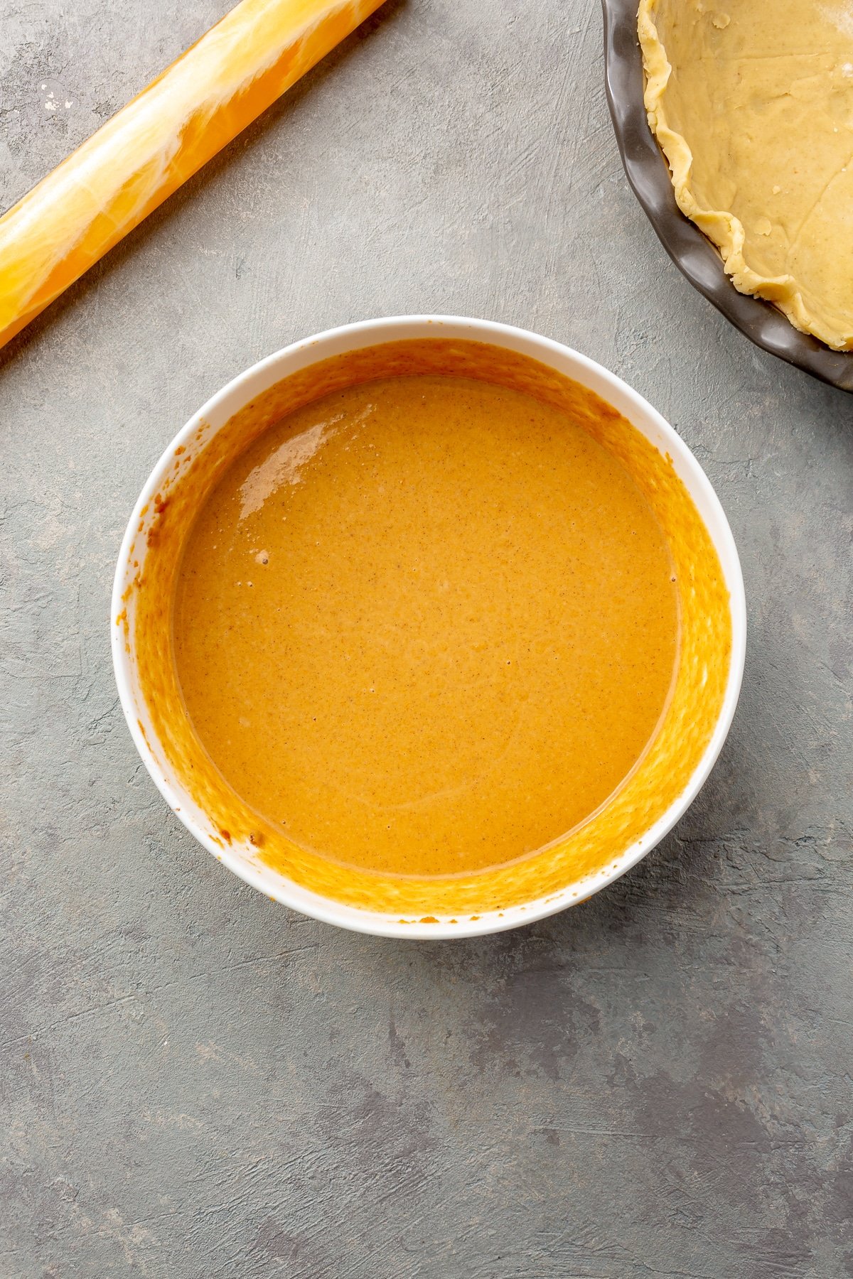 The pumpkin mixture and cream have been fully combined to create a light orange mixture.
