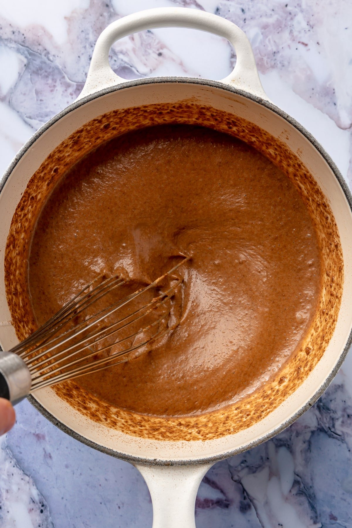 Ingredients are shown being whisked together to create a thick brown mixture.
