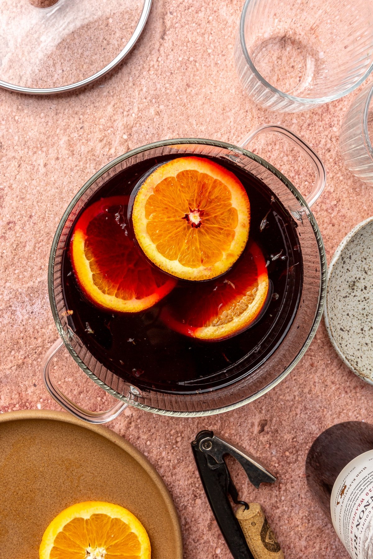 Three orange slices and other ingredients have been added to the wine.