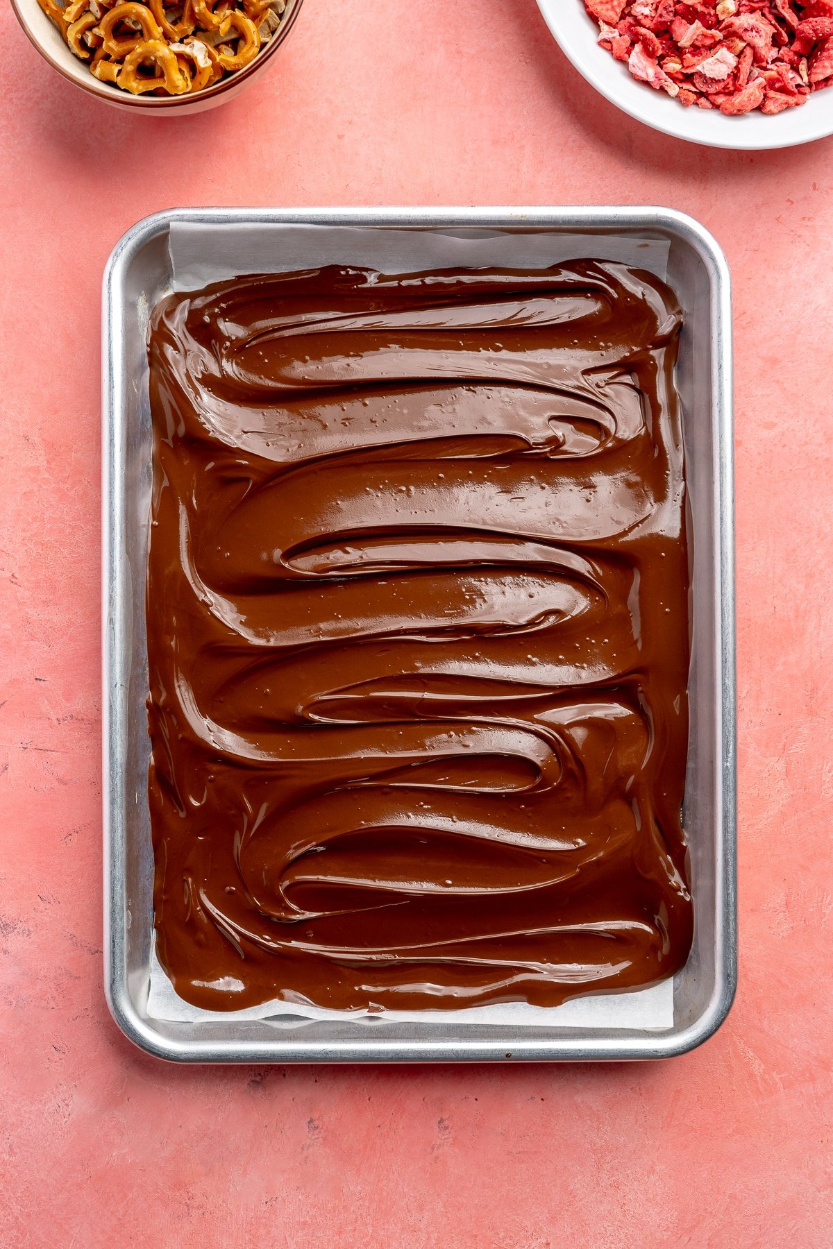 The melted chocolate has been spread into an even layer covering the bottom of the tray.