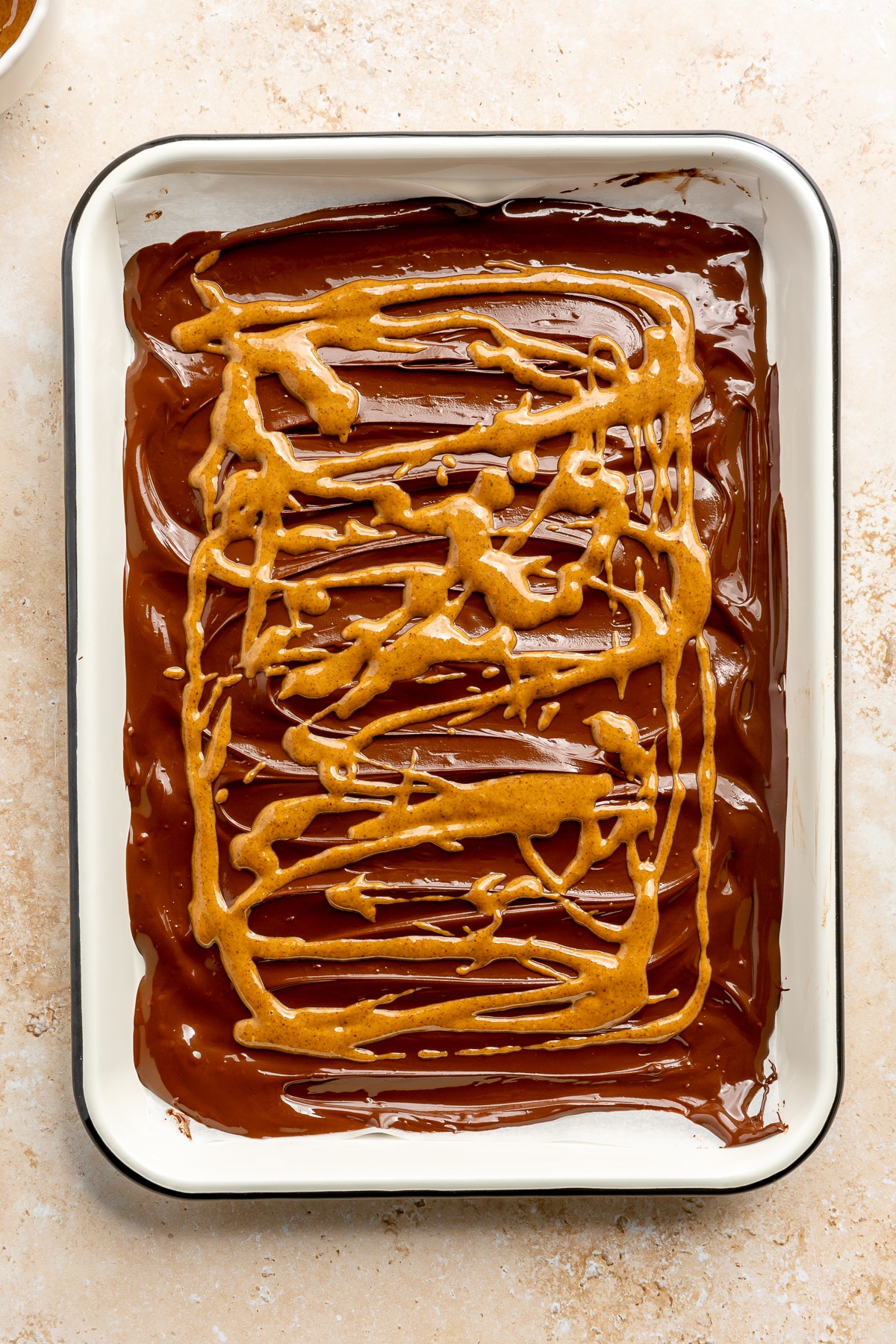 Peanut butter has been drizzled over the top of the chocolate layer.