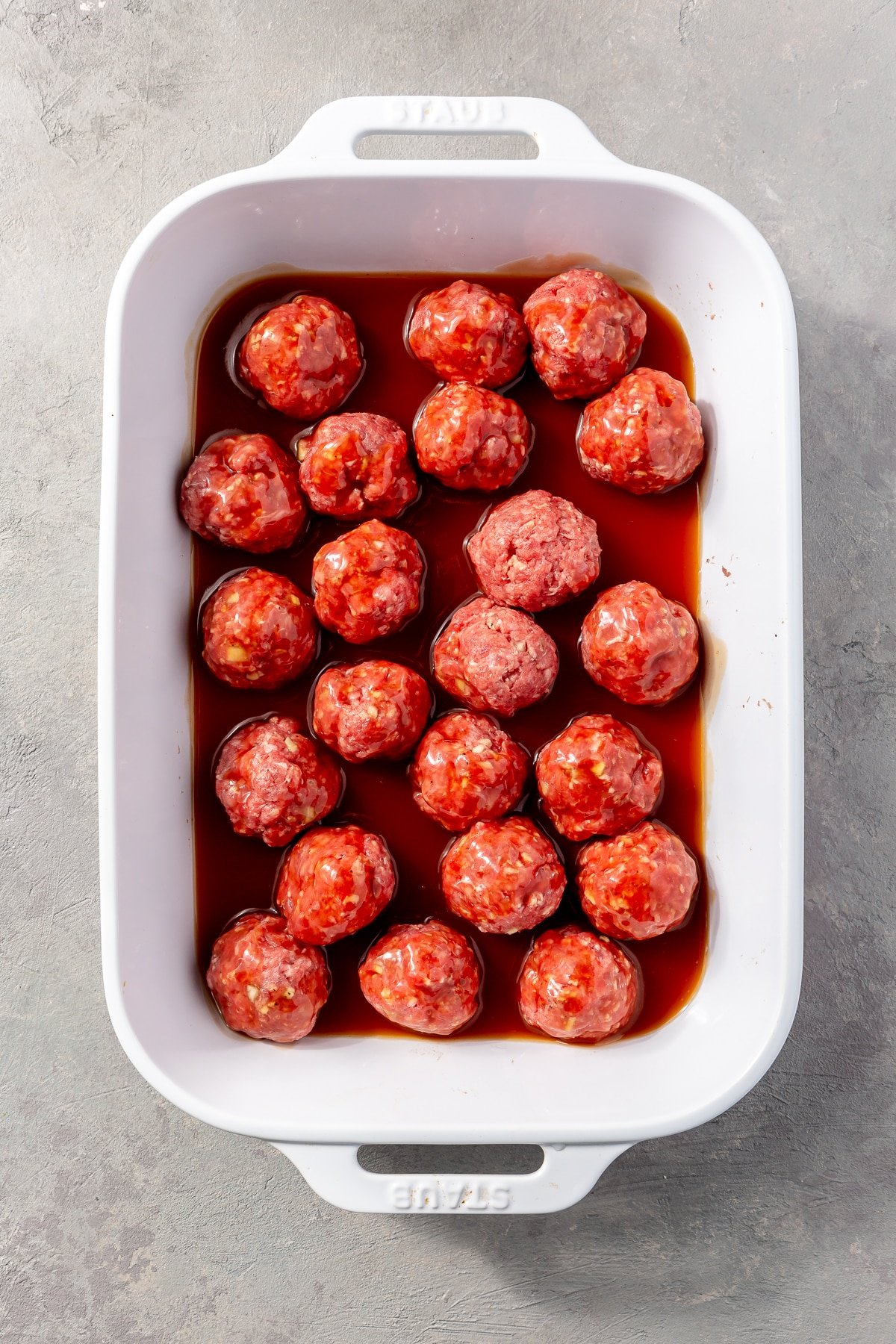 The red sauce has been poured over the top of the meatballs.
