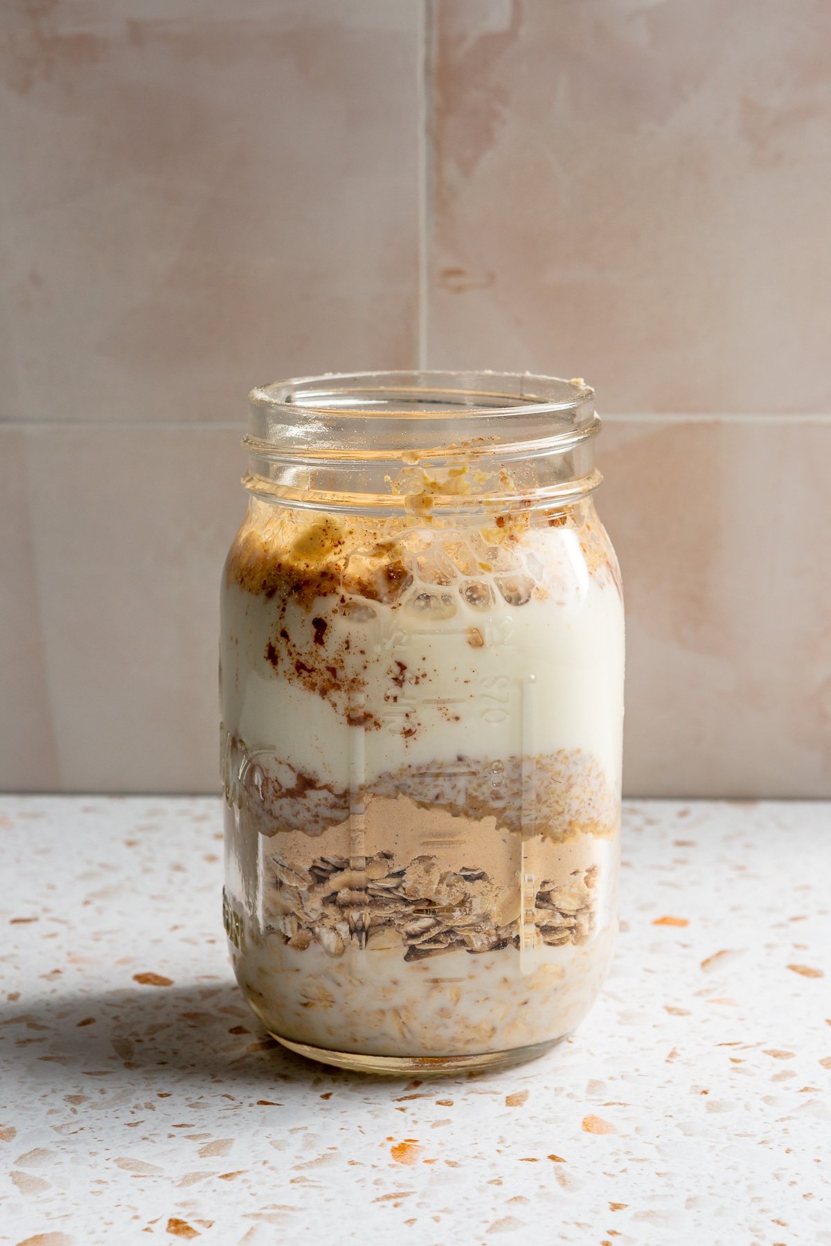 Ingredients for high protein overnight oats have been added to a mason jar.