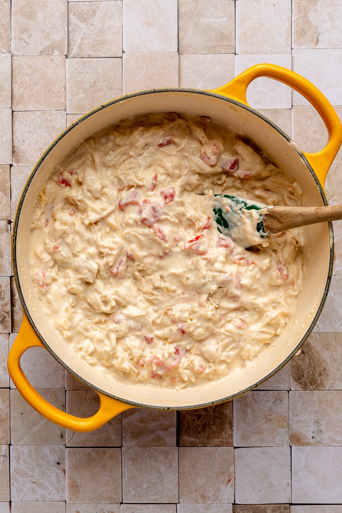 Shredded chicken and diced tomatoes have been added and all have been mixed to create a creamy mixture.